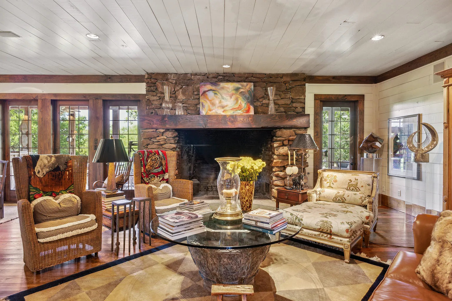 Great room with pine floors and floor-to-ceiling stone wood-burning fireplace