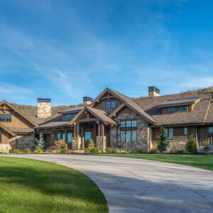 Luxurious mountain ranch Craftsman home plan with stone and wood siding, multiple gables, covered porch and stone chimneys - 3,623 sq ft front exterior rendering