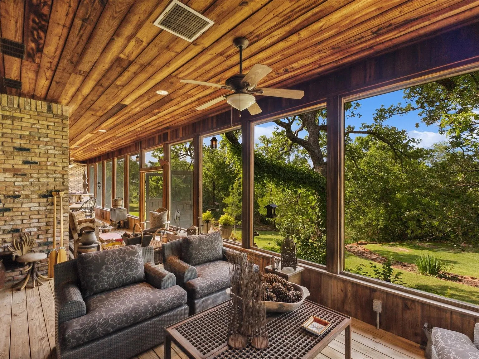 Screened porch with cedar plank ceilings overlooking Texas oaks