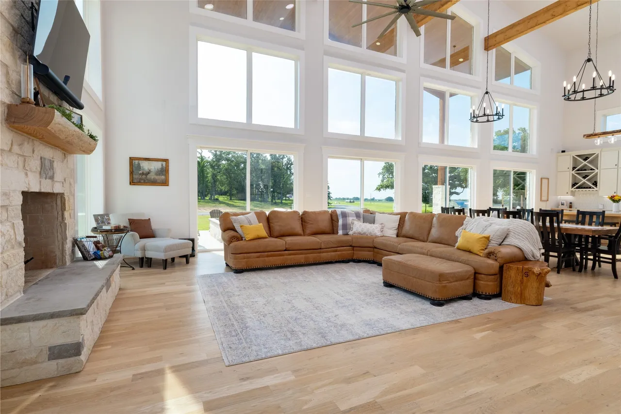 Two-story great room with limestone fireplace and a wall of windows