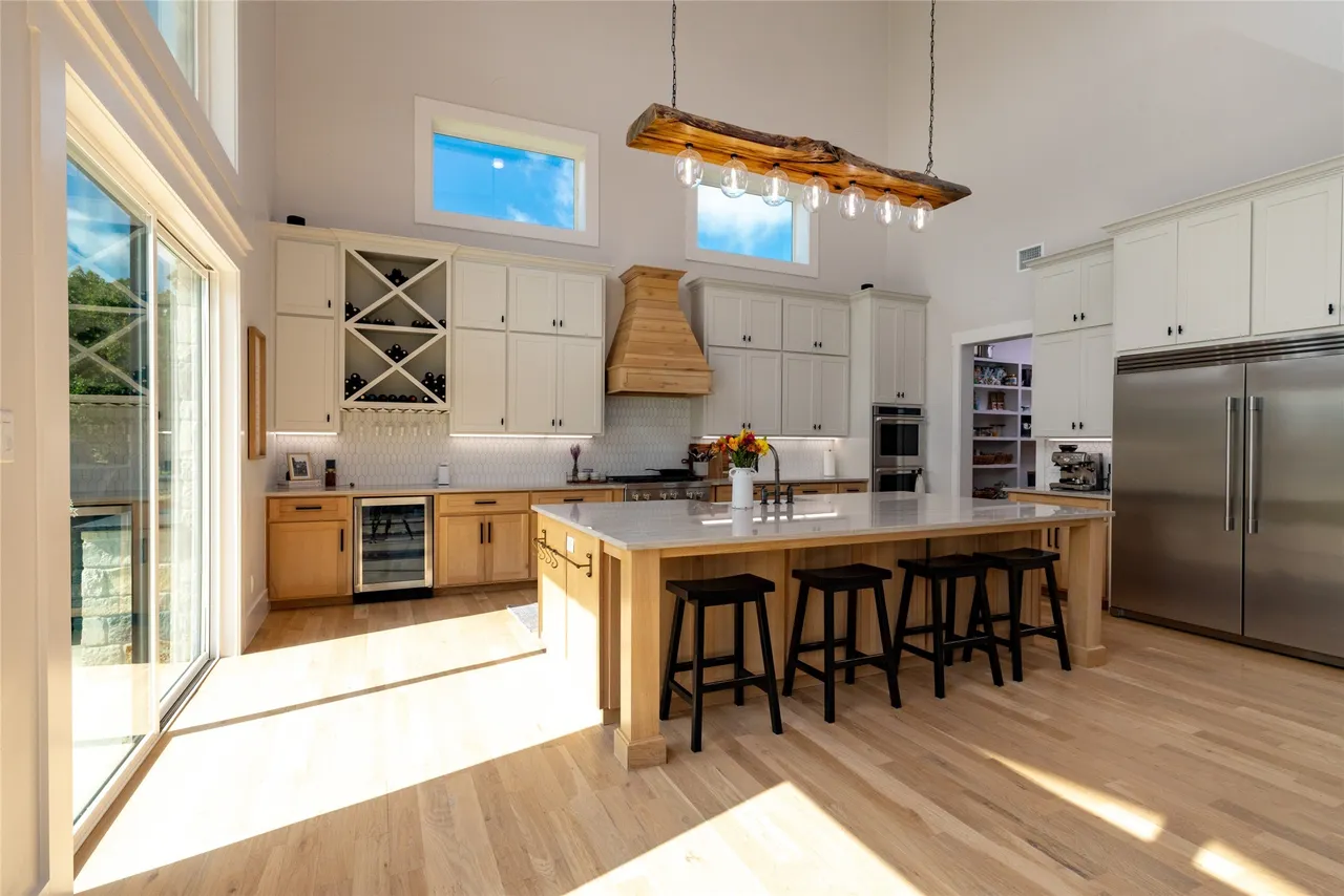 Kitchen with timber range hood, oak island and log pendant light