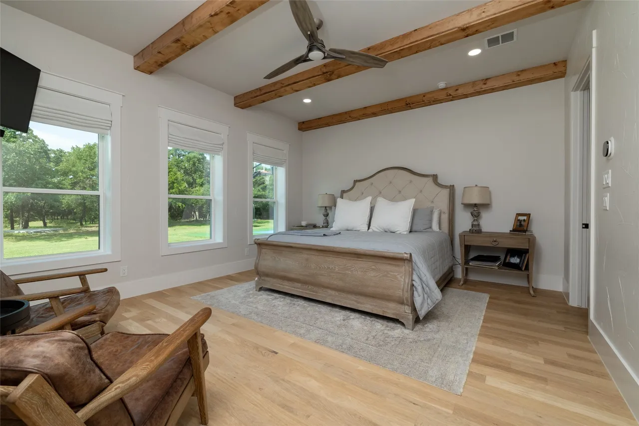 Primary bedroom with exposed beams and pasture views