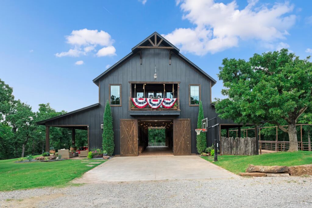 Black barn exterior with enormous natural wood doors on forty acres in Arcadia, Oklahoma