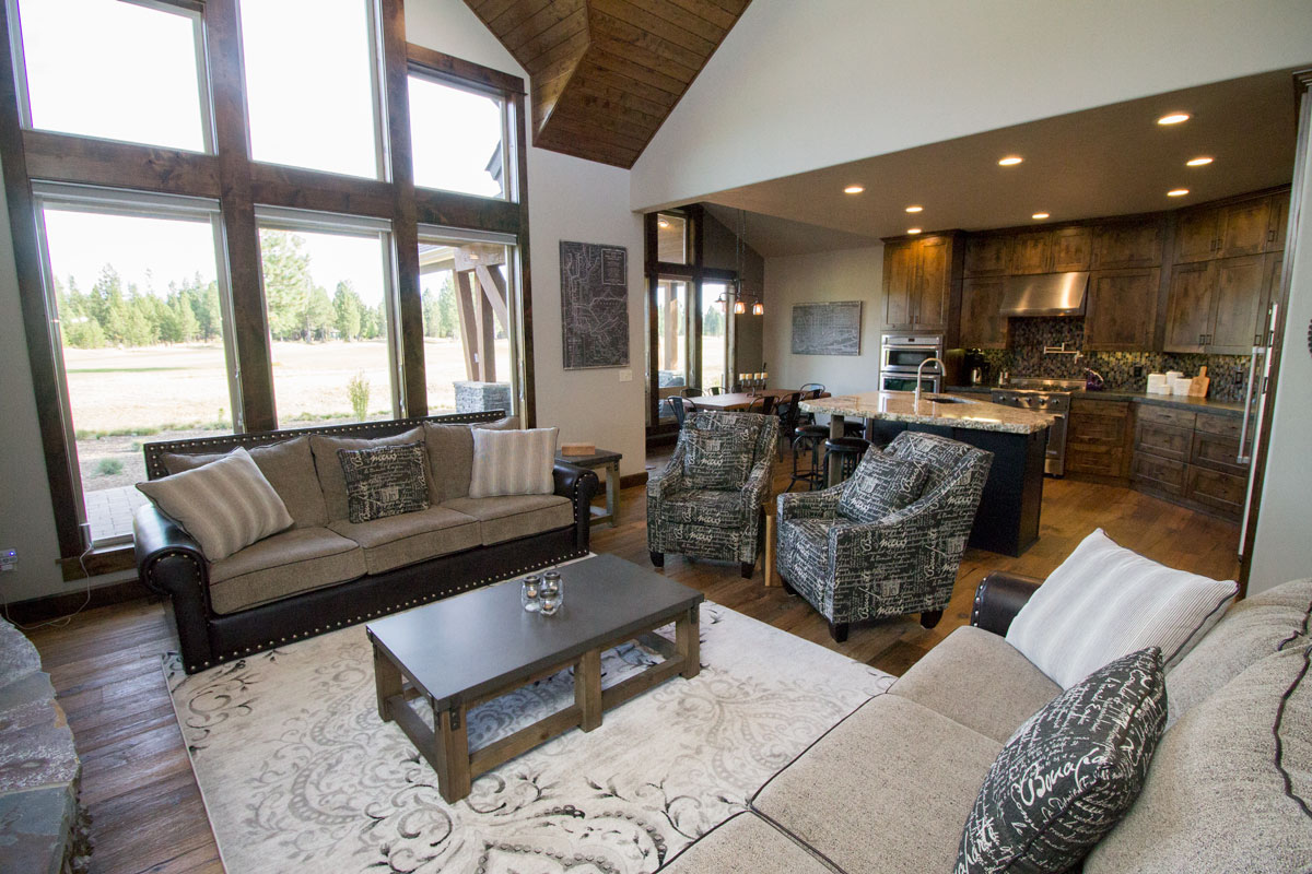 Open great room and kitchen under a vaulted wood ceiling with large island