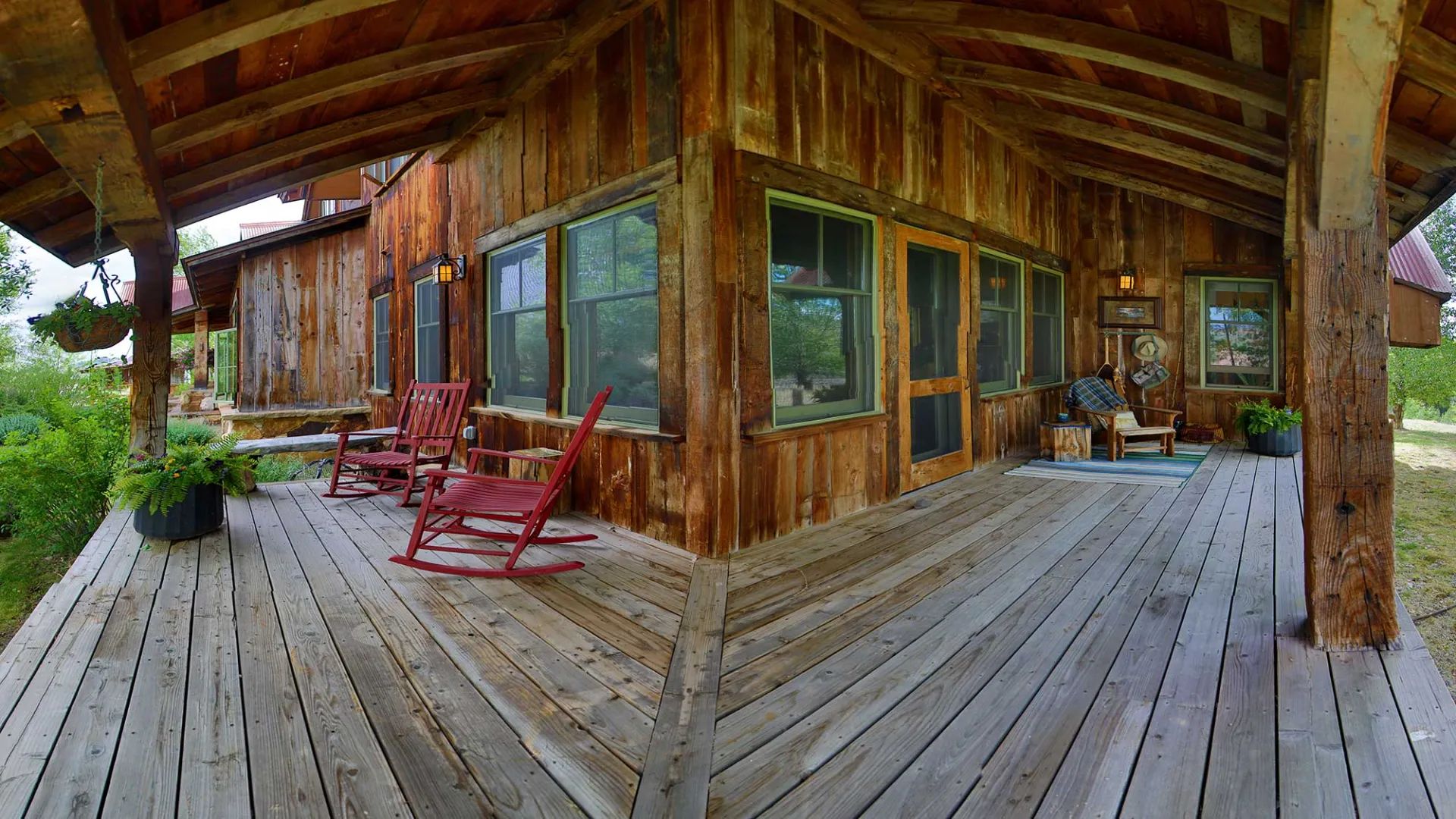 Covered timber porch with red rocking chairs at Eagle Ridge Ranch