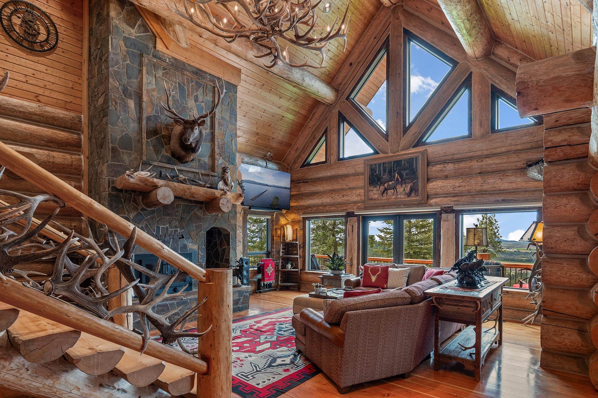 Great room with a wall of windows framing mountain views at Painted Rose Ranch