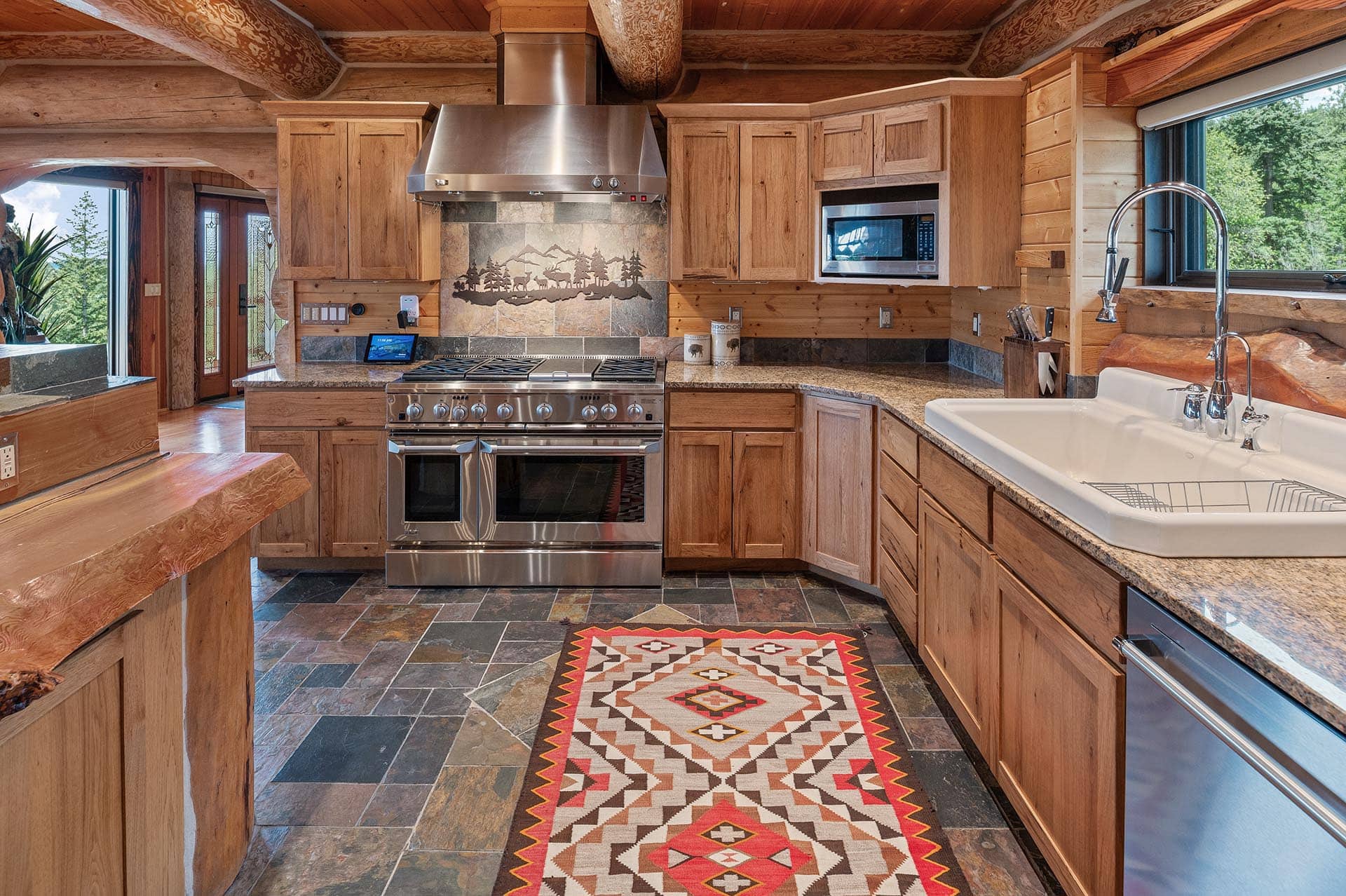 Log home kitchen with stainless range at Painted Rose Ranch